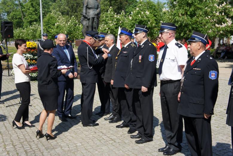01 - Sławomir Kowalewski i Leszek Ośliźlok dekorują strażaków medalami Zasłużony dla Miasta Mława