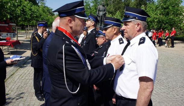 Sławomir Kowalewski i Leszek Ośliźlok dekorują strażaków medalami Zasłużony dla Miasta Mława