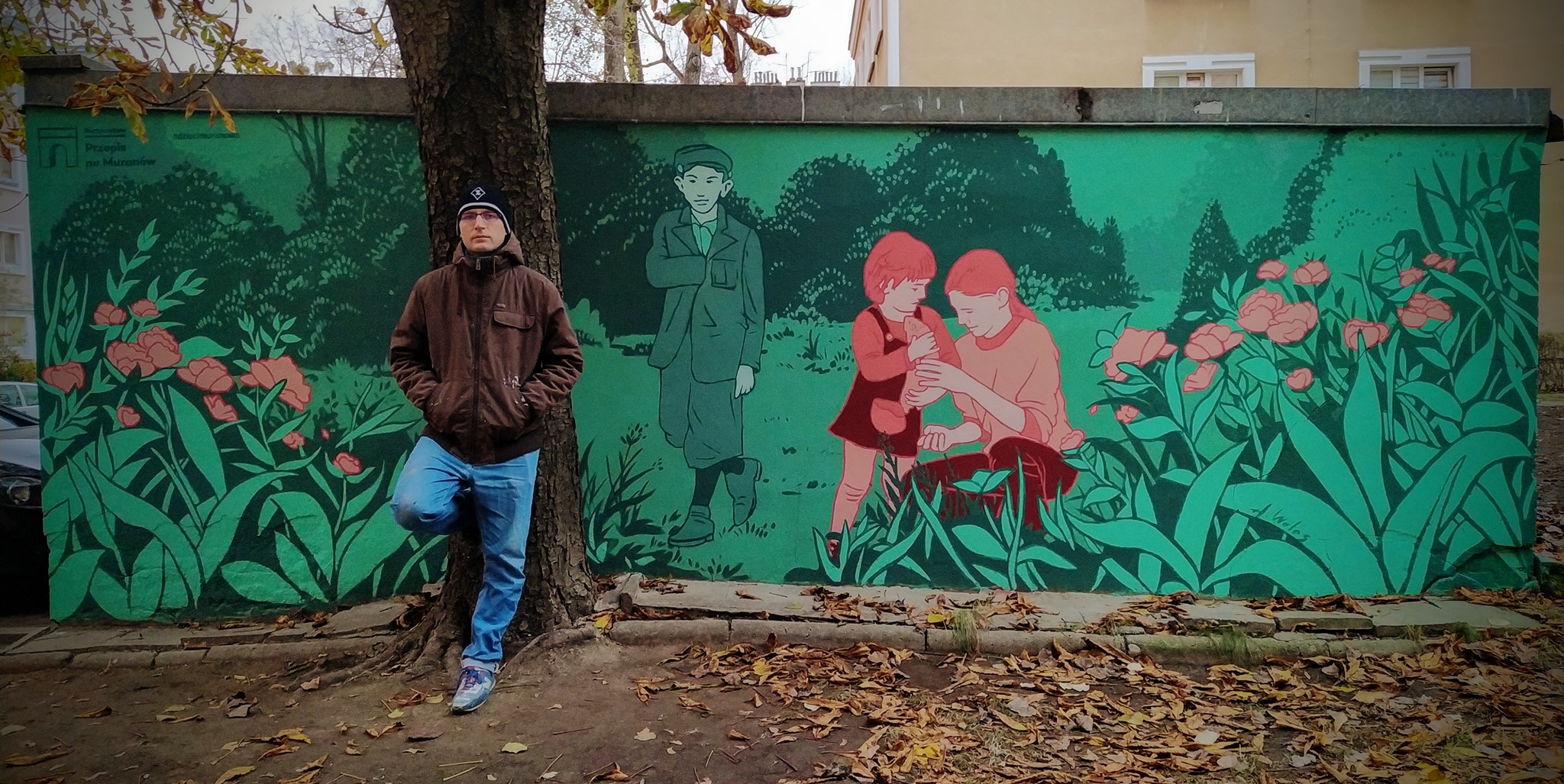Adam Walas na tle muralu "Dzieci Muranowa"