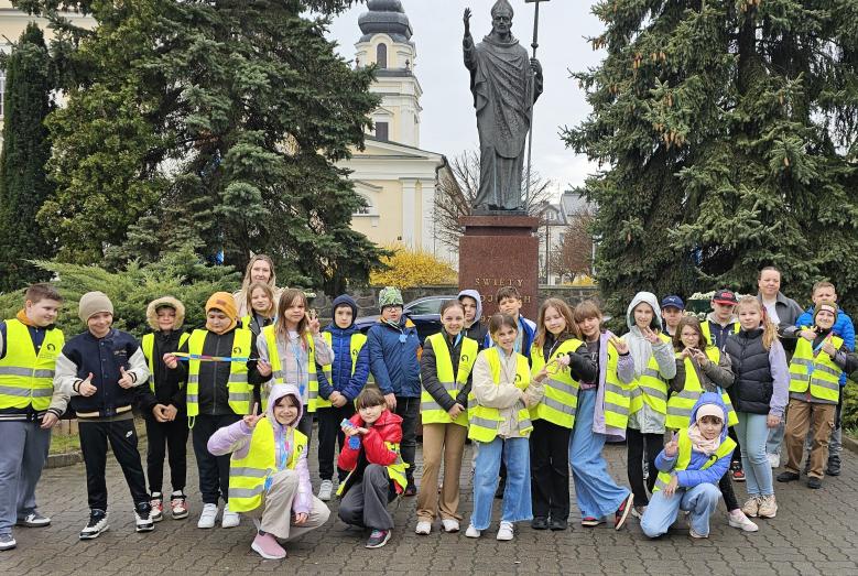 uczniowie i nauczycielki Szkoły Podstawowej nr 2 w Mławie przed pomnikiem św. Wojciecha