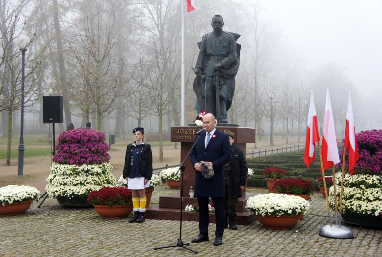 Burmistrz Miasta Mława Sławomir Kowalewski przed pomnikiem Józefa Piłsudskiego