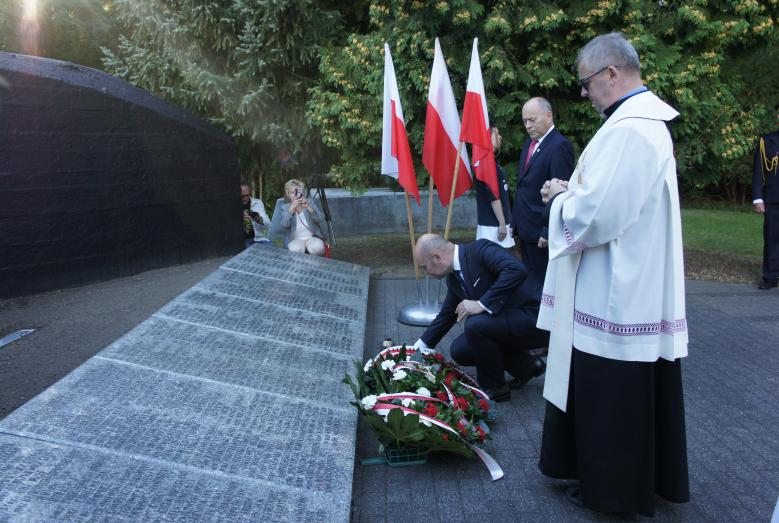 Kwiaty składają Sławomir Kowalewski, Lech Prejs i ks. Sławomir Krasiński