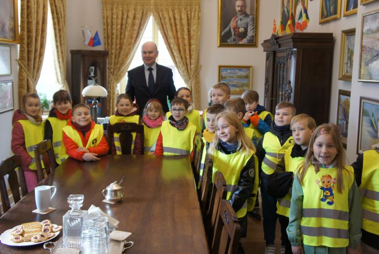 burmistrz Sławomir Kowalewski z dziećmi w kamizelkach odblaskowych