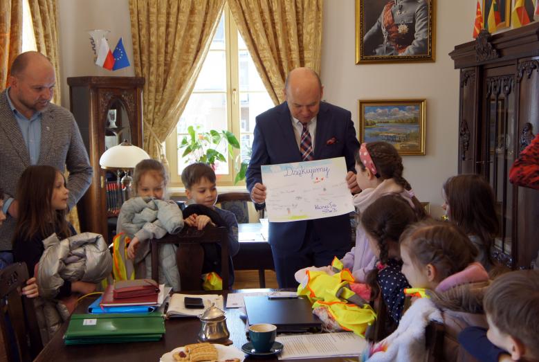 Dzieci wręczają burmistrzowi Sławomirowi Kowalewskiemu pamiątkowe podziękowanie