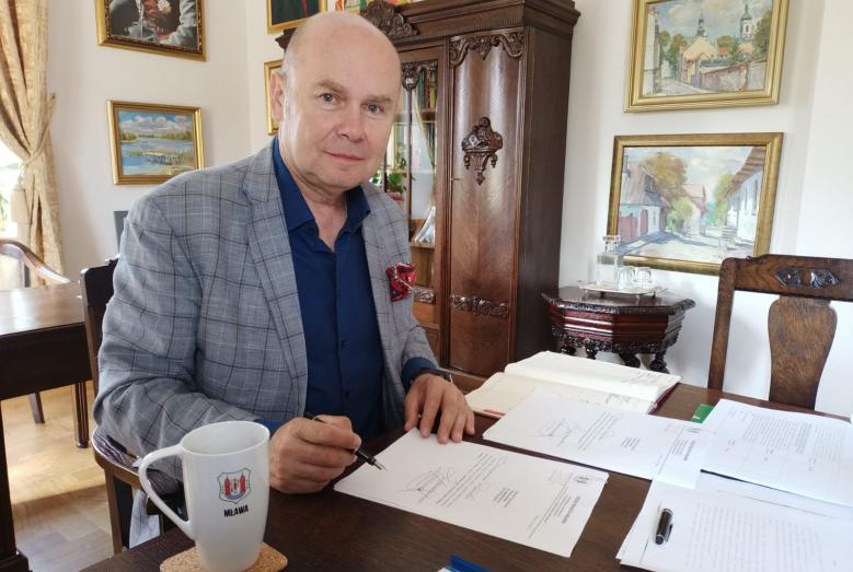 Burmistrz Sławomir Kowalewski podpisuje wnioski o dofinansowanie przebudowy dróg w Mławie