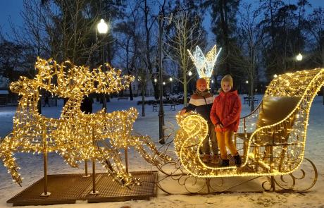 iluminowana ozdoba świąteczna w parku miejskim, dwoje dzieci