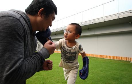 chłopiec trenujący kickboxing z dorosłym mężczyzną