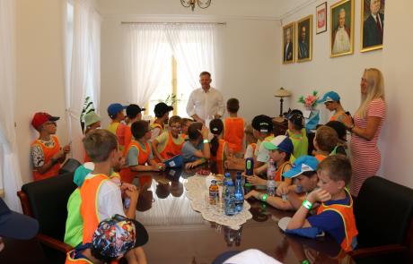 Burmistrz Piotr Jankowski wraz z odwiedzającymi go dziećmi