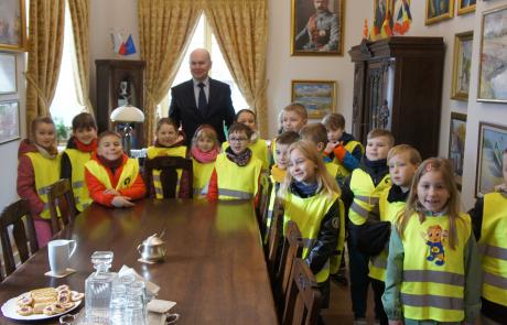 burmistrz Sławomir Kowalewski z dziećmi w kamizelkach odblaskowych