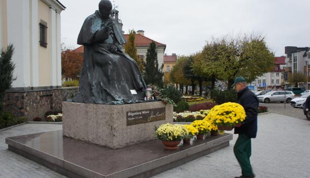 Pracownicy Agrosanu przyozdabiają pomnik św. Jana Pawła II na Starym Rynku