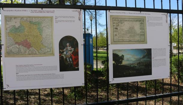 Dwie plansze wystawy na ogrodzeniu parku