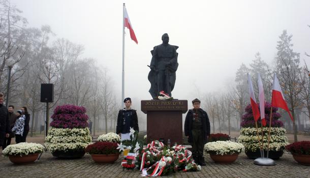 Pomnik Józefa Piłsudskiego, dwoje harcerzy, złożone kwiaty