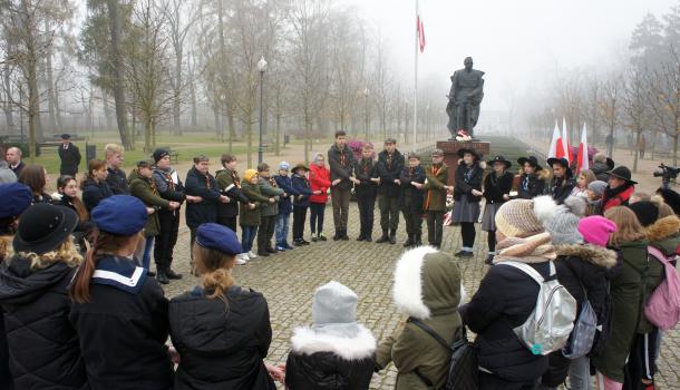 Krąg harcerzy przed pomnikiem Józefa Piłsudskiego