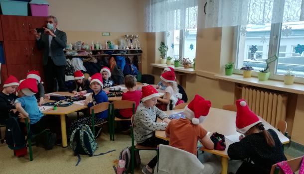 Oddziały przedszkolne przy Szkole Podstawowej Nr 6, dzieci w czapkach mikołaja siedzą przy stolikach 