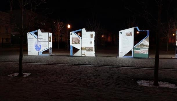Trzy plansze wystawy w parku nocą