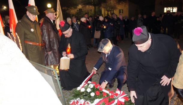 Kwiaty i znicze pod pomnikiem składają ks. kan. Sławomir Krasiński, burmistrz Sławomir Kowalewski i ks. prał. dr Kazimierz Ziółkowski