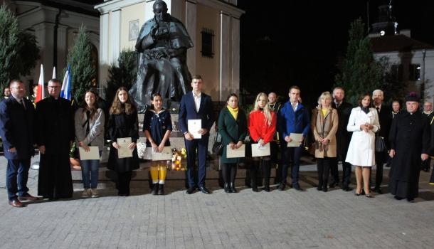 stypendyści i darczyńcy przed pomnikiem Jana Pawła II